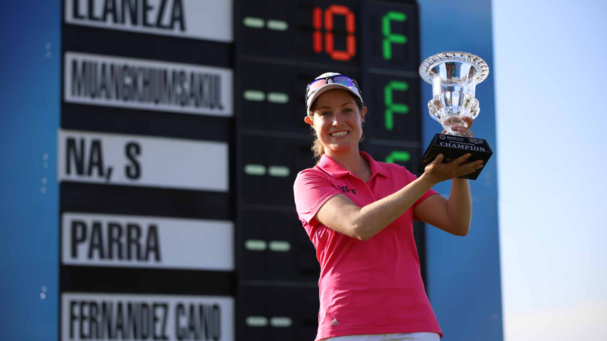 Alejandra Llaneza with trophy at leaderboard